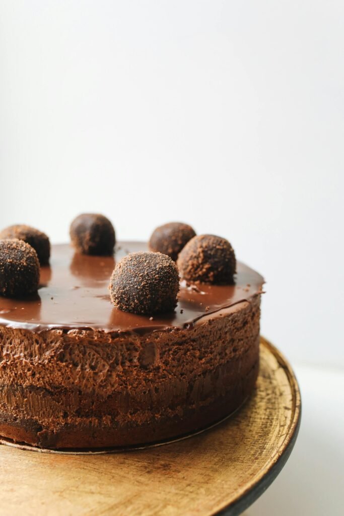 Indulge in a rich chocolate mousse cake topped with truffles, perfect for dessert lovers.